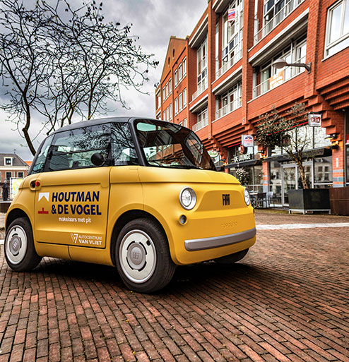 gele auto met logo van houtman en de vogel erop
